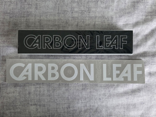 Two stickers with 'Carbon Leaf' branding on a gray textured background